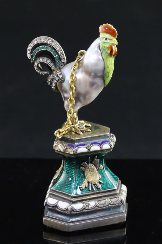 An Austro-Hungarian style baroque pearl, rose diamond and emerald set model of a cockerel, now on silver and enamel stand,